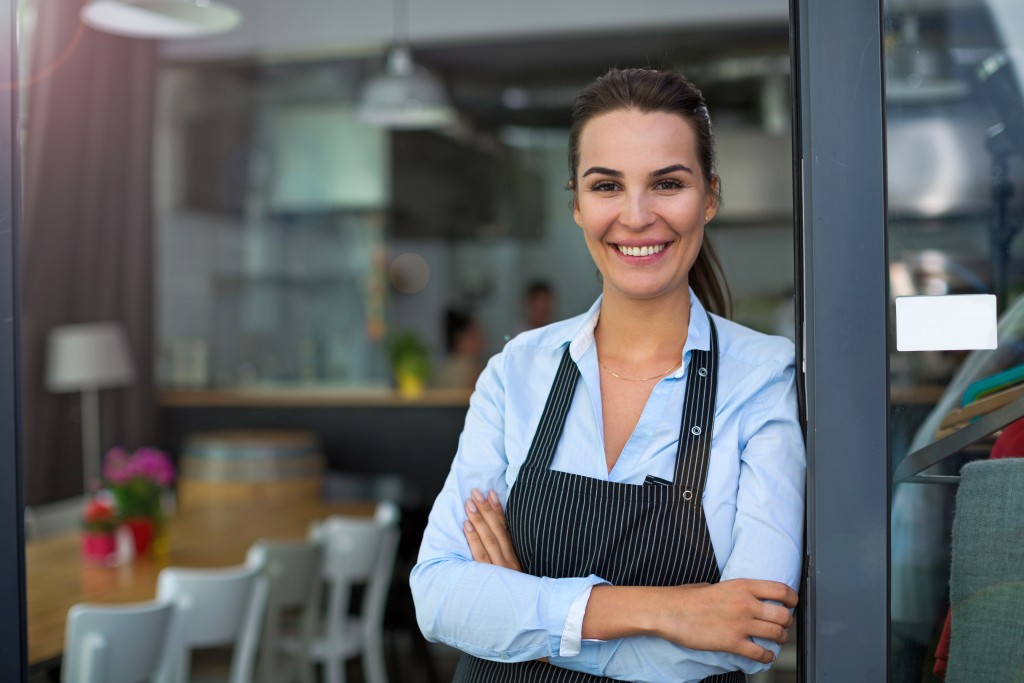 Business owner standing at the door of restaurant