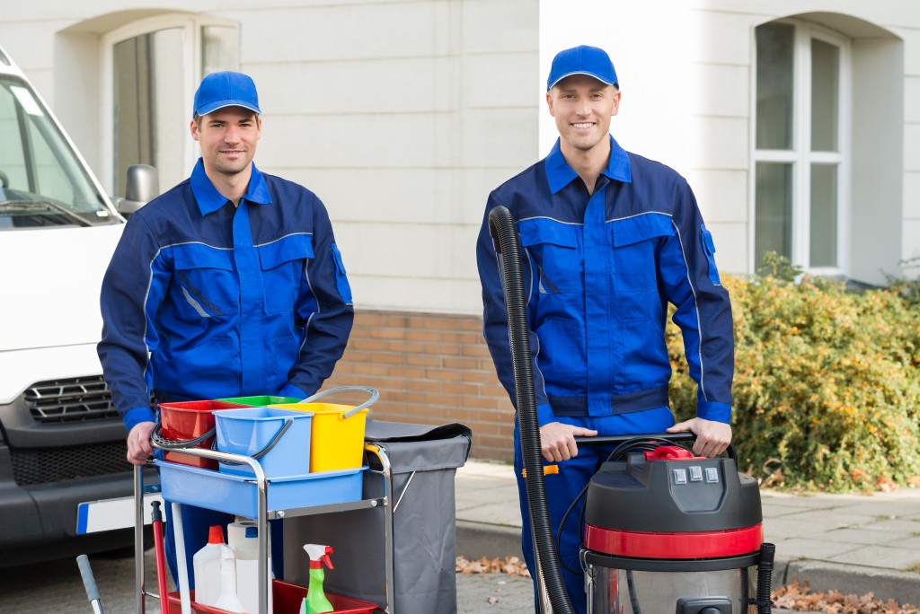 Men holding cleaning equipment