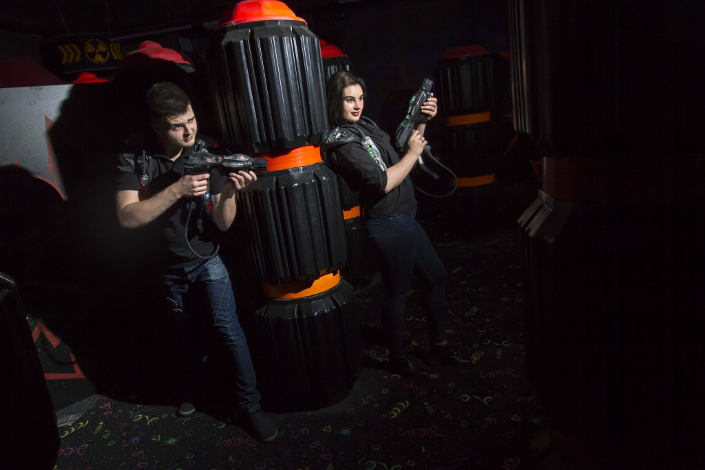 man and woman playing laser tag