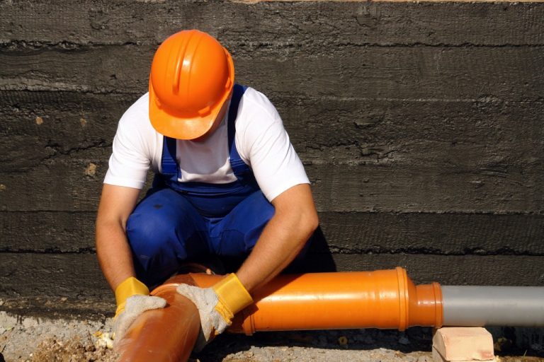man fixing a sewer pipe