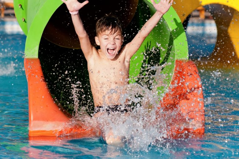 kid coming out from the slide in a water park
