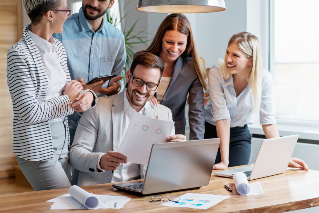 boss and employees happily discussing with each other