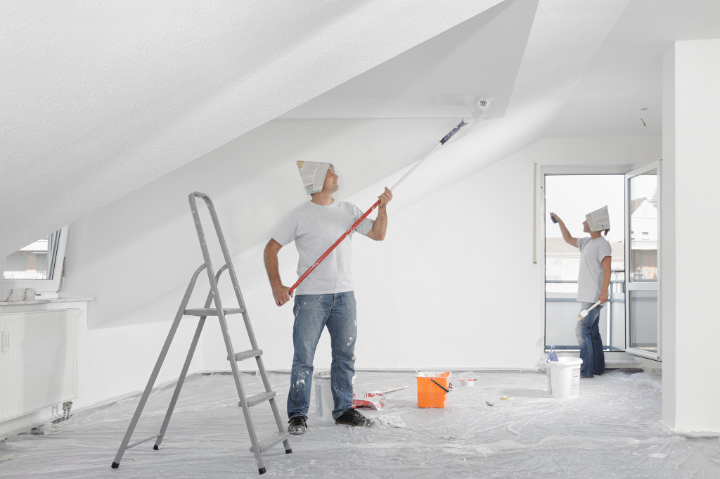 Workers painting walls with white color
