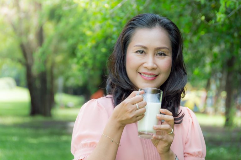 woman drinking milk outdoors