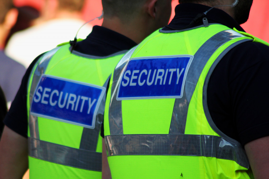 Image of two male security Guards with bright tops on