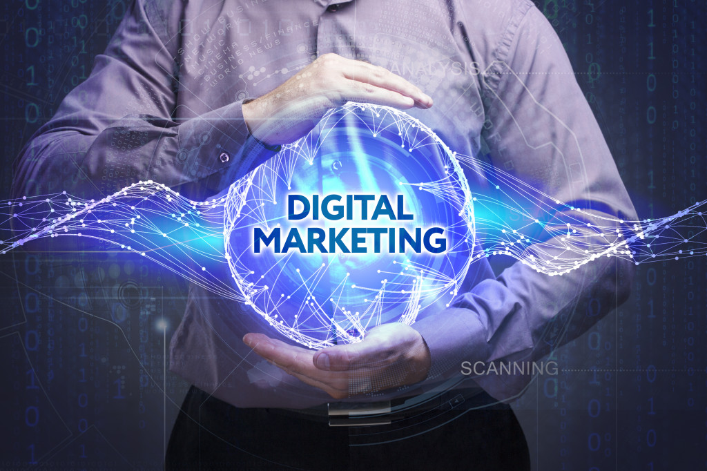 Businessman holding a visual representation of a ball of light with the words digital marketing on it.